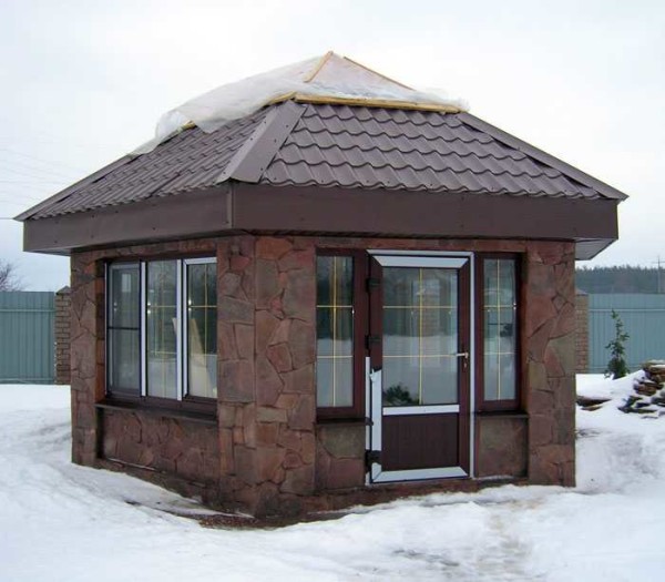 Et eksempel på et stort glassert lysthus trimmet med vill stein. Enhver byggestein kan være i bunnen. Glass med doble vinduer