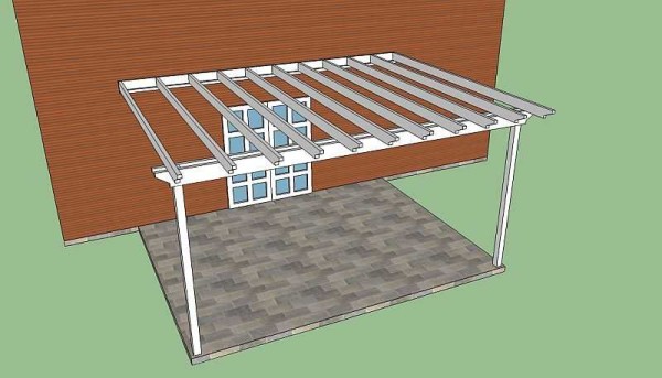 La pérgola cerca de la casa descansa en un lado de los pilares, el otro en la pared del edificio.