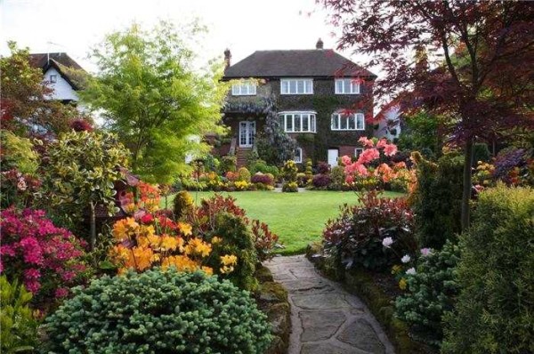 Vegetazione rigogliosa intervallata da prati ben curati - segni di un giardino inglese