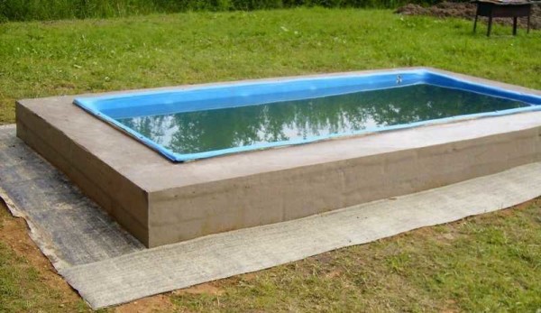 Il materiale di copertura viene posato sul terreno livellato intorno alla piscina