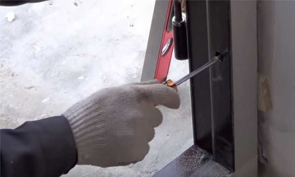 Mettiamo l'ancora nel telaio della porta della porta d'ingresso dal basso, controllando la verticalità del rack