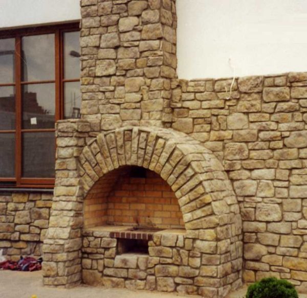 Frente a la chimenea con piedra se puede hacer al aire libre