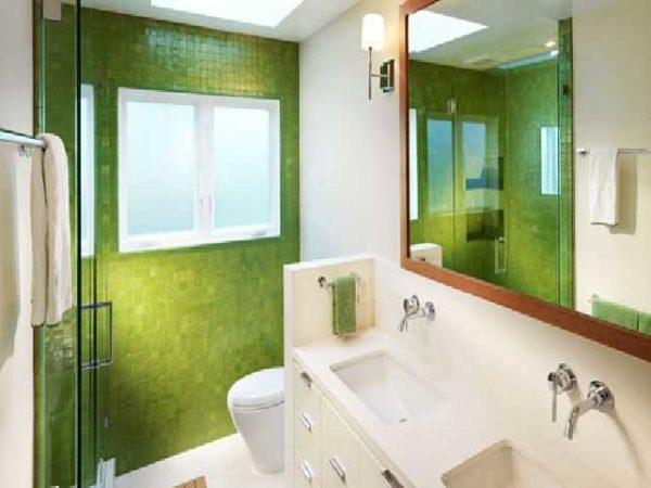 La pared de mosaico verde en un baño pequeño refresca el interior