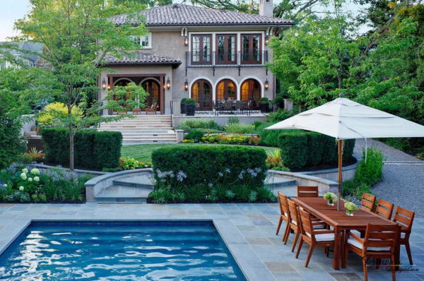 Paisajismo del patio de una casa privada con piscina cerca de la puerta.